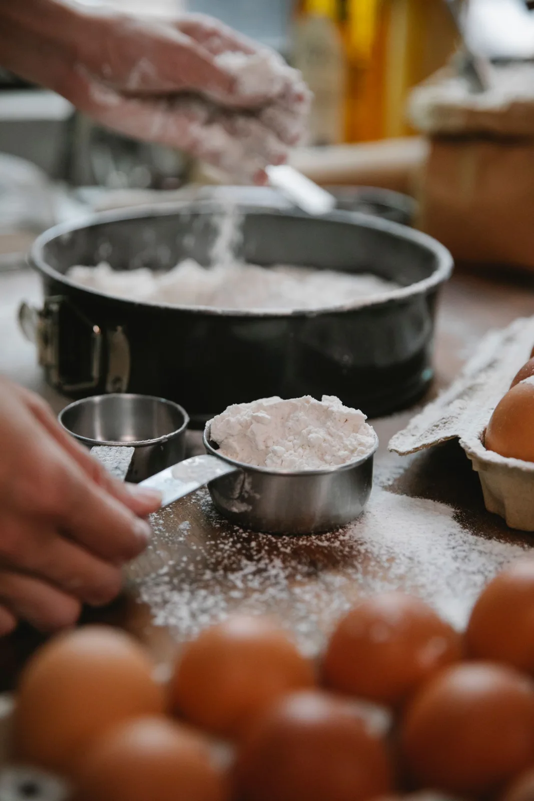 Flour being added to a baking pan on a kitchen counter