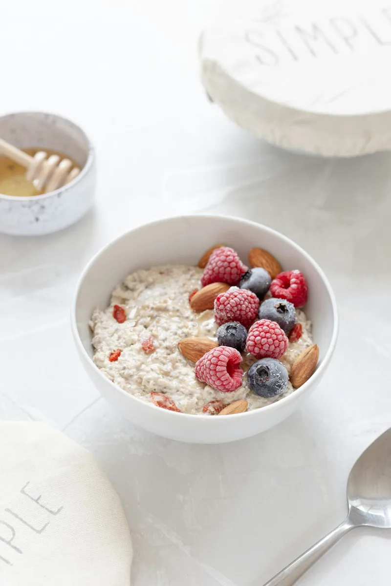 A bowl of oats topped with raspberries and blueberries