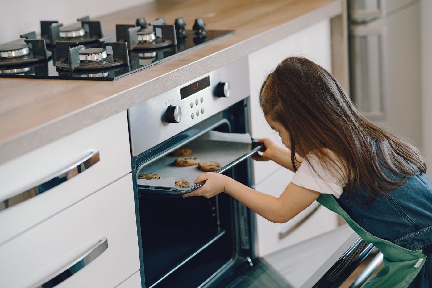 A family baking scene beside an oven