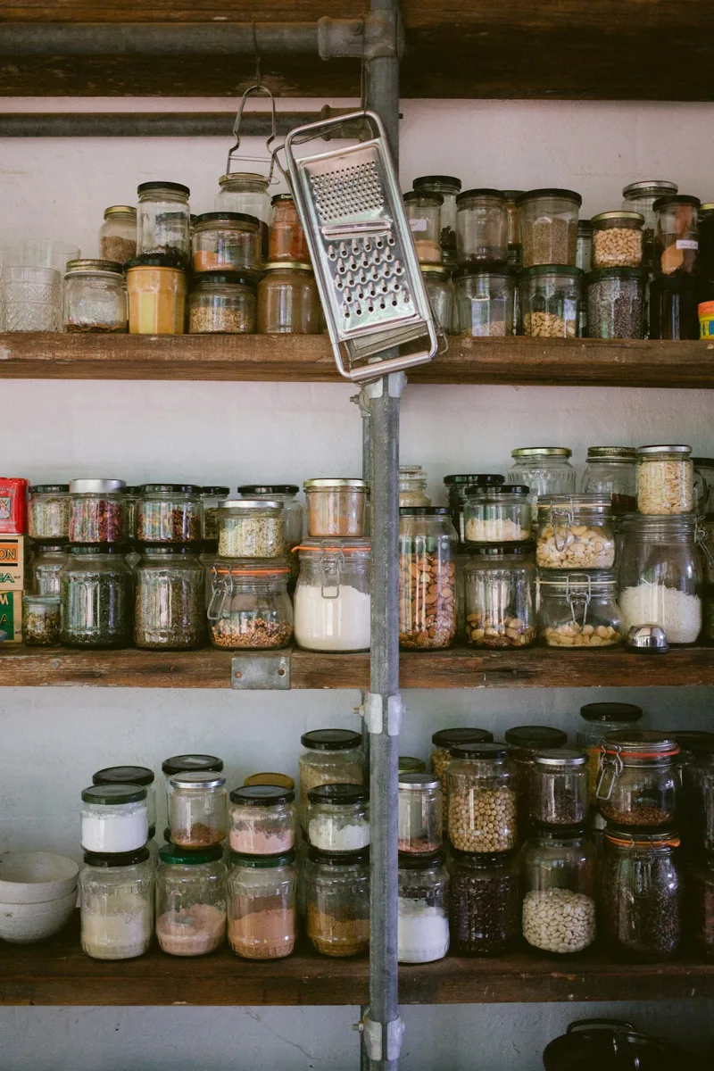 Kitchen pantry shelves lined with glass jars of dry ingredients