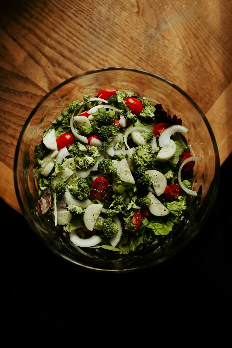 A large green salad with cucumber and tomatoes in a bowl