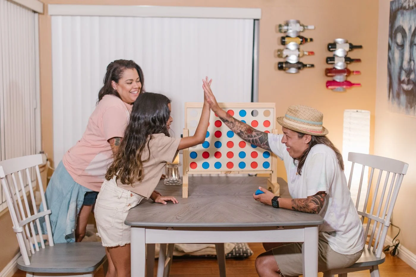 Family sharing a tabletop game and a high five indoors