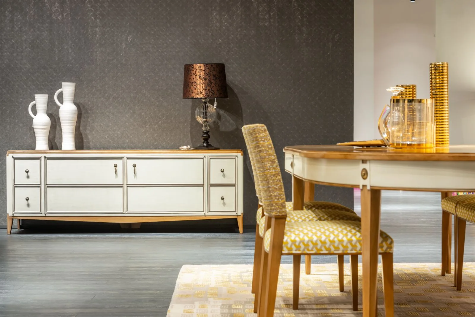 A dining table and wooden chairs beside a pale sideboard