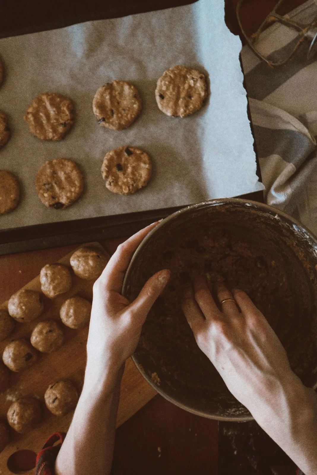 Cookie dough being mixed beside a tray of cookies